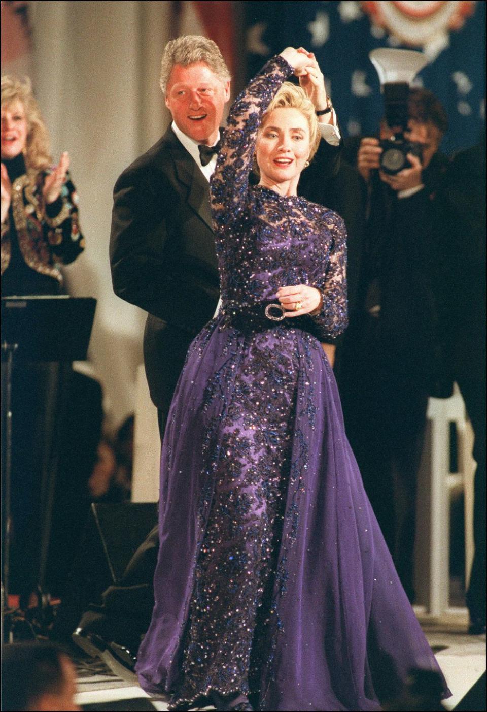 <p>President Bill Clinton gives Hillary Clinton a twirl as they share the first dance at his inaugural ball. The First Lady looked lovely in a purple beaded ball gown with a tulle skirt that was <a href="https://www.si.edu/newsdesk/photos/hillary-clintons-inaugural-gown-1993" rel="nofollow noopener" target="_blank" data-ylk="slk:designed by Sarah Phillips;elm:context_link;itc:0;sec:content-canvas" class="link ">designed by Sarah Phillips</a>. </p>