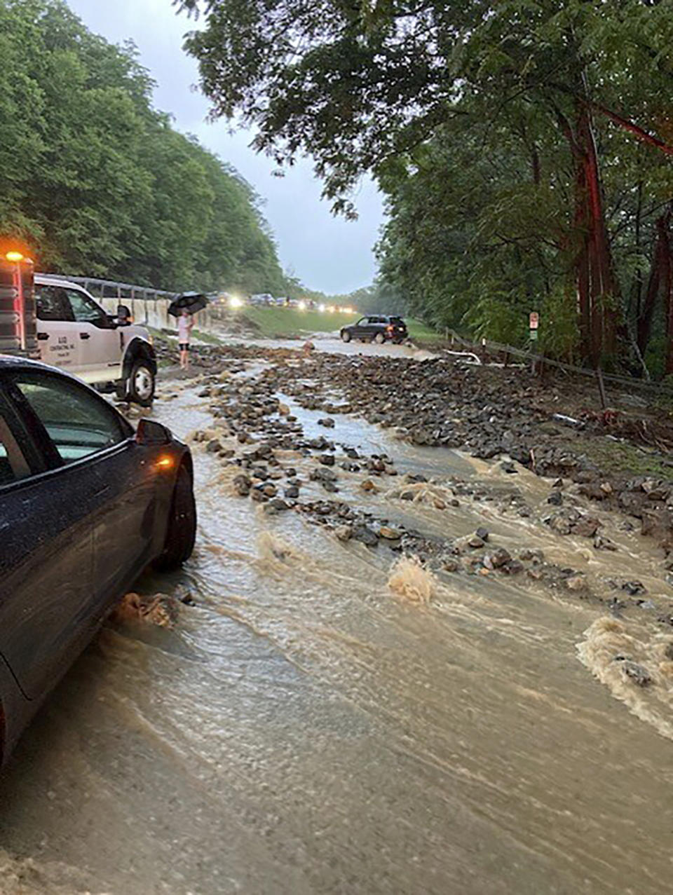 Vehicles come to a standstill near a washed-out and flooded portion of the Palisades Parkway just beyond the traffic circle off the Bear Mountain Bridge, Sunday, July 9, 2023, in Orange County, N.Y. Heavy rain spawned extreme flooding in New York’s Hudson Valley that killed at least one person, swamped roadways and forced road closures on Sunday night, as much of the rest of the Northeast U.S. geared up for a major storm. (AP Photo/David Bauder)
