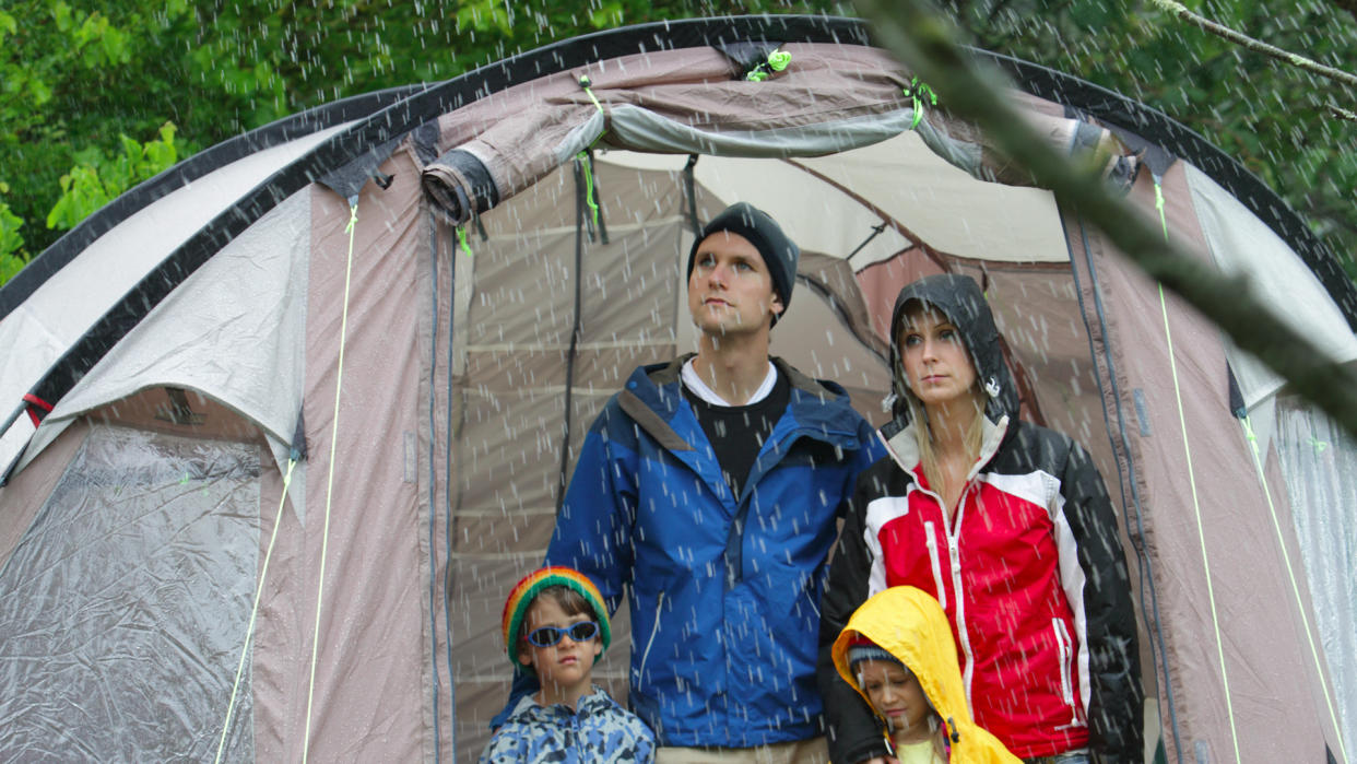  Family looking out from tent at rain. 