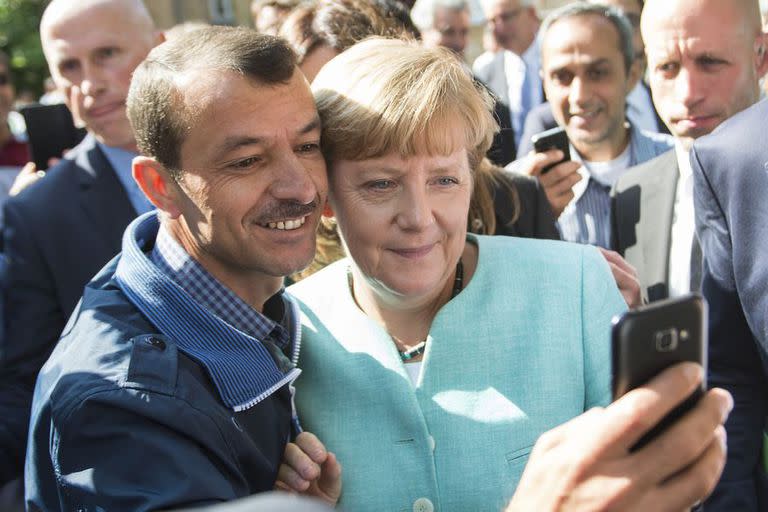 Merkel se saca una selfie con un refugiado sirio. Alemania abrió las puertas a los migrantes que huían de la guerra