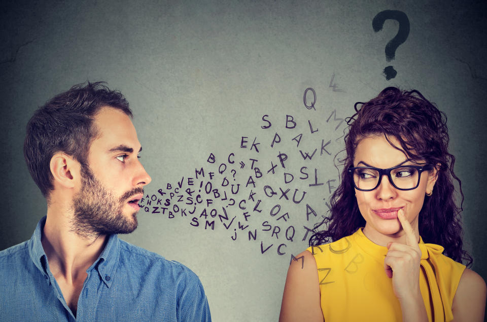 Language barrier concept. Handsome man talking to an attractive young woman with question mark