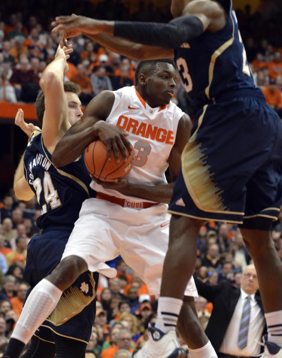 Syracuse's Jerami Grant grabs a rebound against Notre Dame's Pat Connaughton, left, and Demetrius Jackson, during the first half of an NCAA college basketball game in Syracuse, N.Y., Monday, Feb. 3, 2014. (AP Photo/Kevin Rivoli)