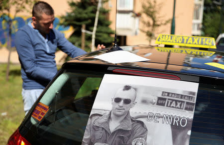 A taxi driver sticks a poster of Robert De Niro on a cab in tribute to the actor who will open the city's film festival on Friday with a screening of "Taxi Driver" in Sarajevo, Bosnia and Herzegovina, August 12, 2016. REUTERS/Dado Ruvic