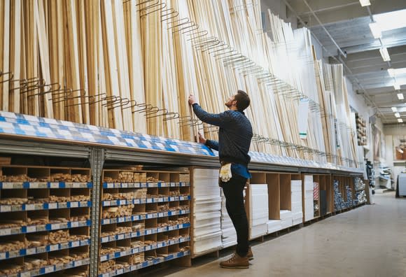 A man looks at wood in a home improvement store.