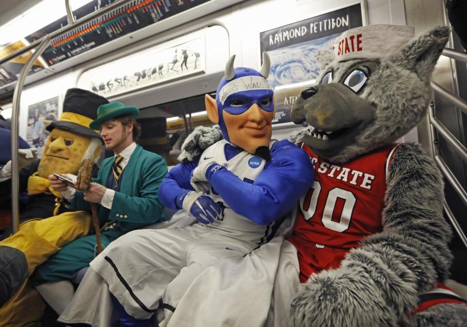 Four of the 15 Atlantic Coast Conference's basketball mascots cram into a New York city subway car for a brief ride, Monday, March 6, 2017, in the Brooklyn borough of New York. All 15 mascots took the ride to promote the ACC basketball tournament March 7-11 at the Barclays Center in Brooklyn. From left, the Wake Forest Demon Deacon, Notre Dame's Leprechaun, Duke's Blue Devil, and North Carolina State's Mr. Wuf. (AP Photo/Kathy Willens)