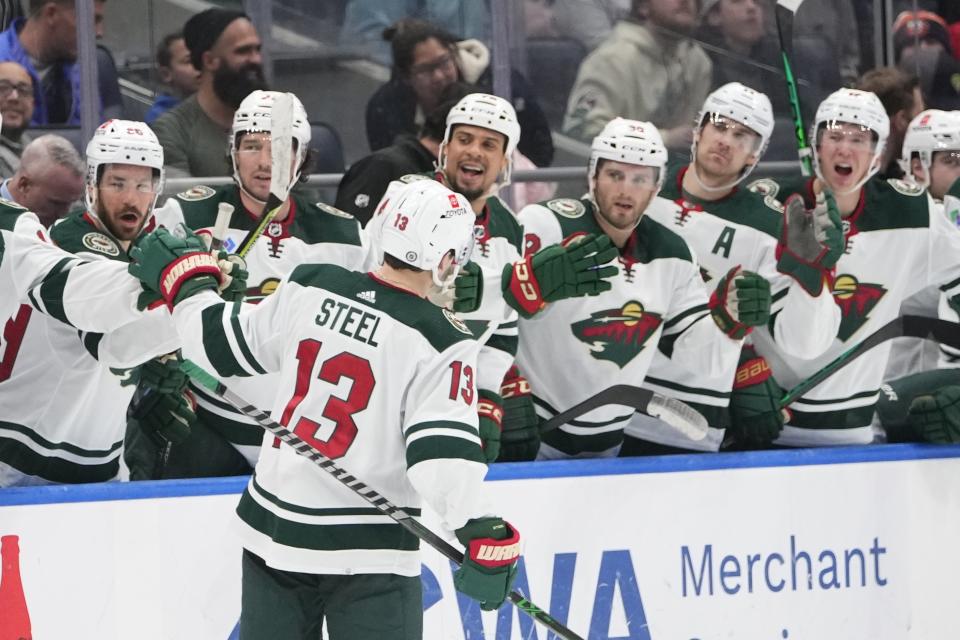 Minnesota Wild's Sam Steel (13) is congratulated for his goal during the third period against the New York Islanders in an NHL hockey game Thursday, Jan. 12, 2023, in Elmont, N.Y. The Wild won 3-1. (AP Photo/Frank Franklin II)