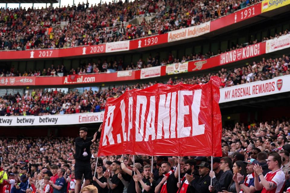 Fans hold up a banner on the 14th minute during Arsenal’s Premier League match against Bournemouth in memory of 14-year-old Daniel Anjorin (PA)