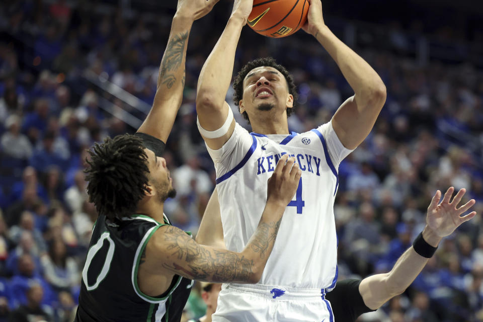 Kentucky's Tre Mitchell, right, shoots while defended by Marshall's Kevon Voyles (0) during the first half of an NCAA college basketball game in Lexington, Ky., Friday, Nov. 24, 2023. (AP Photo/James Crisp)