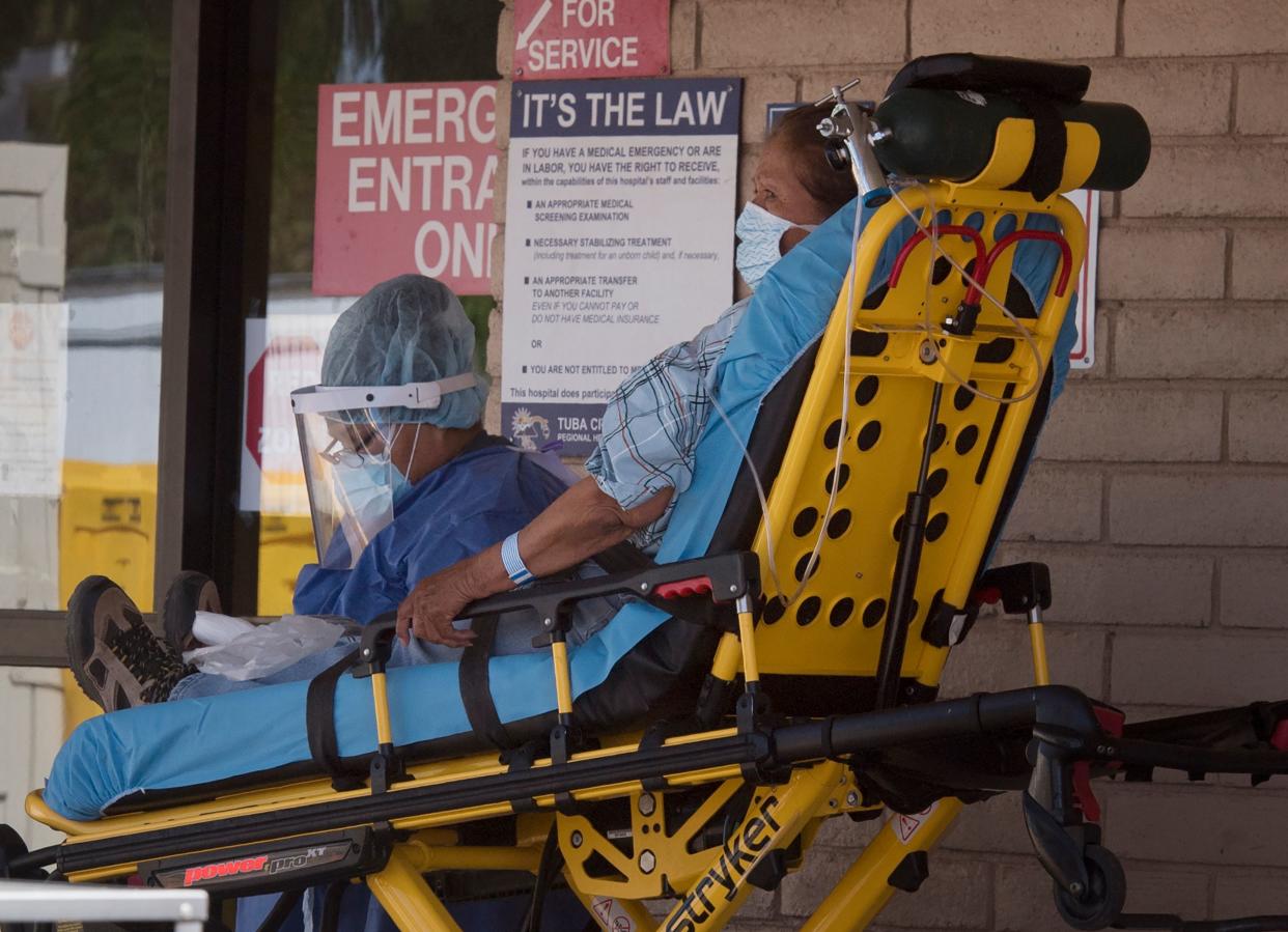 A patient is taken from an ambulance to the emergency room of a hospital in the Navajo Nation town of Tuba City during the 57 hour curfew, imposed to try to stop the spread of the Covid-19 virus through the Navajo Nation, in Arizona on May 24, 2020 - Weeks of delays in delivering vital coronavirus aid to Native American tribes exacerbated the outbreak, the president of the hard-hit Navajo Nation said, lashing the administration of President Donald Trump for botching its response. Jonathan Nez told AFP in an interview that of the $8 billion promised to US tribes in a $2.2 trillion stimulus package passed in late March, the first tranche was released just over a week ago. (Photo by Mark RALSTON / AFP) (Photo by MARK RALSTON/AFP via Getty Images)