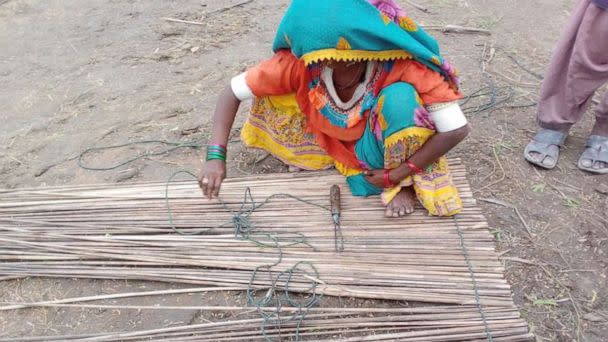 PHOTO: A community member crafts matting from shelter materials in the Karigar village near Pono Markaz, an area designed for rehabilitation and livelihood opportunities for flood-affected communities in the southeastern Pakistan, on July 16, 2022. (Yasmeen Lari / Heritage Foundation of Pakistan)