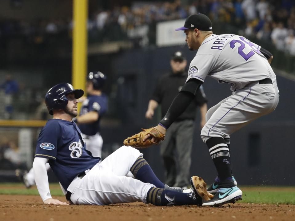 Colorado Rockies' Nolan Arenado tags out Milwaukee Brewers' Travis Shaw during the third inning of Game 2 of the National League Divisional Series baseball game Friday, Oct. 5, 2018, in Milwaukee. (AP Photo/Jeff Roberson)