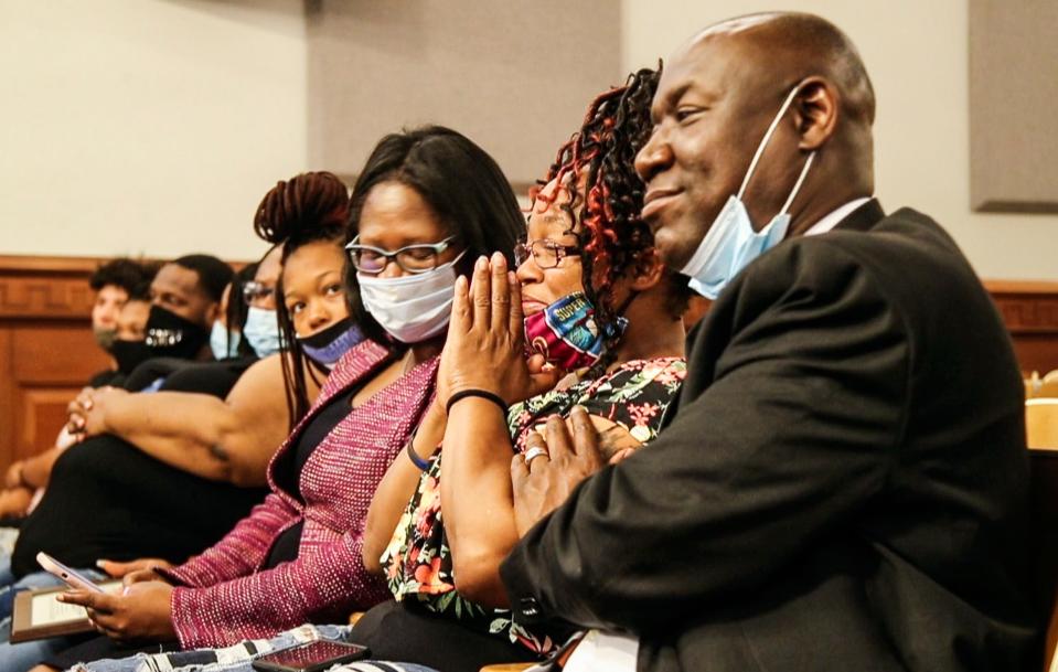 Tamika Palmer holds up her hands as the Metro Council votes to ban no-knock warrants in honor of her daughter Breonna Taylor Thursday night in Louisville. At right is Ben Crump, a Florida-based attorney representing Taylor's family. June 11, 2020