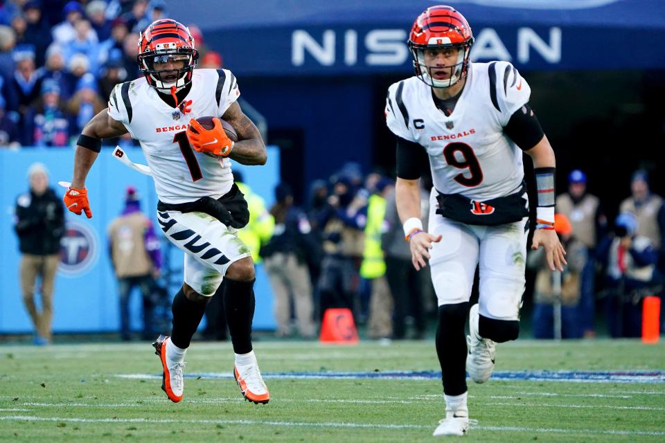 Cincinnati Bengals wide receiver Ja'Marr Chase (1) carries the ball as Cincinnati Bengals quarterback Joe Burrow (9) blocks in the first quarter during an NFL divisional playoff football game against the Tennessee Titans, Saturday, Jan. 22, 2022, at Nissan Stadium in Nashville.