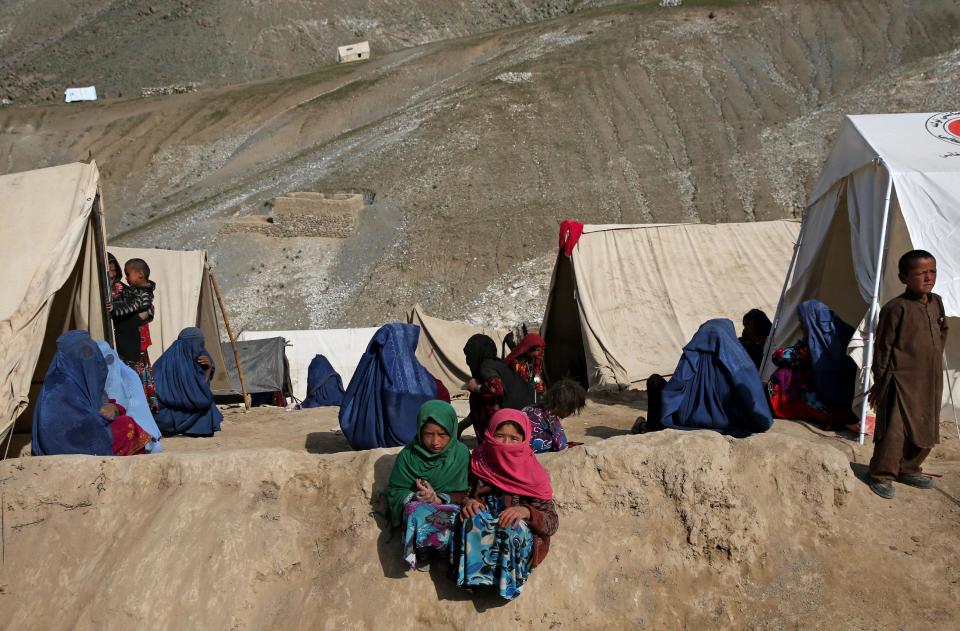 Survivors sit in front of their tents near the site of Friday's landslide that buried Abi-Barik village in Badakhshan province, northeastern Afghanistan, Tuesday, May 6, 2014. Authorities tried to help families displaced by the torrent of mud that swept through Abi-Barik village after hundreds were killed. (AP Photo/Massoud Hossaini)