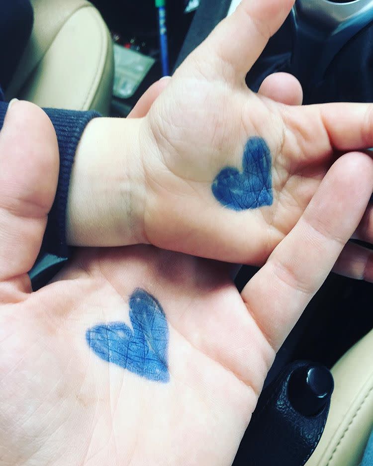 The pair draws a blue heart on each other’s hands and loads it up with cuddles to last the day. Source: Facebook/ Charly Holmes.