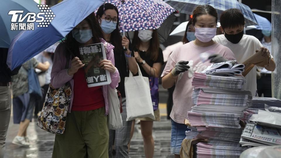 讀者們依序排隊購買，絲毫不受天雨影響。（圖／達志影像美聯社）