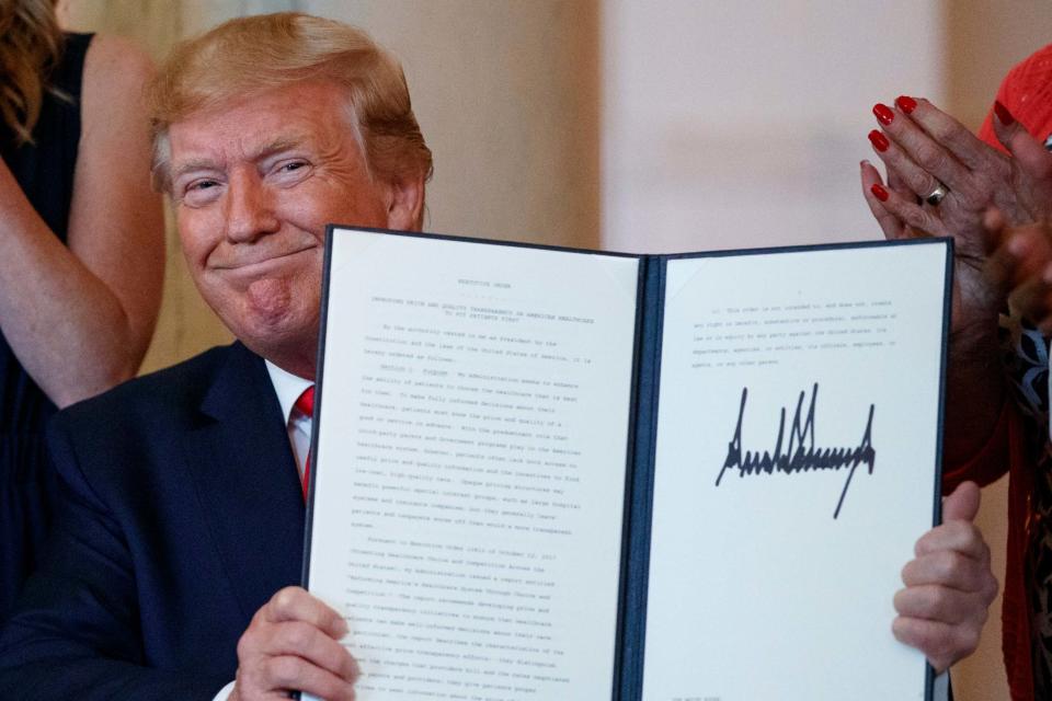 Donald Trump holds up the executive order which he signed to introduce more sanctions on Iranian officials (AP)