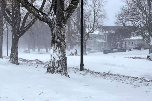 PHOTO: A person clears snow from the sidewalk during a snowstorm, Dec. 24, 2022 in Buffalo, N.Y. (Carolyn Thompson/AP)