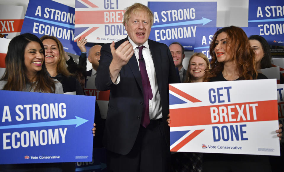 El primer ministro británico, Boris Johnson, en el centro, habla con activistas y simpatizantes mientras posa para una foto en la sede del centro de llamadas de la campaña conservadora, en un acto electoral en Londres el domingo 8 de diciembre de 2019. (Ben Stansall/Pool Photo via AP)