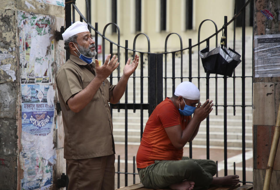 In this Friday, April 24, 2020, photo, Muslims perform prayers outside the Baitul Mukkaram National Mosque, closed due to the lockdown, in Dhaka, Bangladesh. Bangladesh, a nation of 160 million people, is struggling to keep its number of infections in check as community transmission of the virus has invaded the common people across the country. (AP Photo/Al-emrun Garjon)