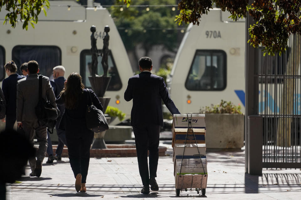 A stack of boxes is wheeled away by the team of attorneys representing the PGA Tour outside a federal courthouse in San Jose, Calif., Tuesday, Aug. 9, 2022. A federal judge has ruled that three golfers who joined Saudi-backed LIV Golf will not be able to compete in the PGA Tour's postseason. (AP Photo/Godofredo A. Vásquez)