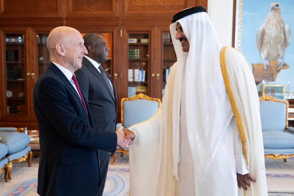 Qatar's Amir Sheikh Tamim bin Hamad al-Thani (R) shaking hands with Britain's Minister of Defence John Healey as Britain's Minister of Foreign Affairs David Lammy (C) stands by, at the office at the Amiri Diwan in Doha on July 31, 2024 (Qatar Amiri Diwan/AFP via Getty)