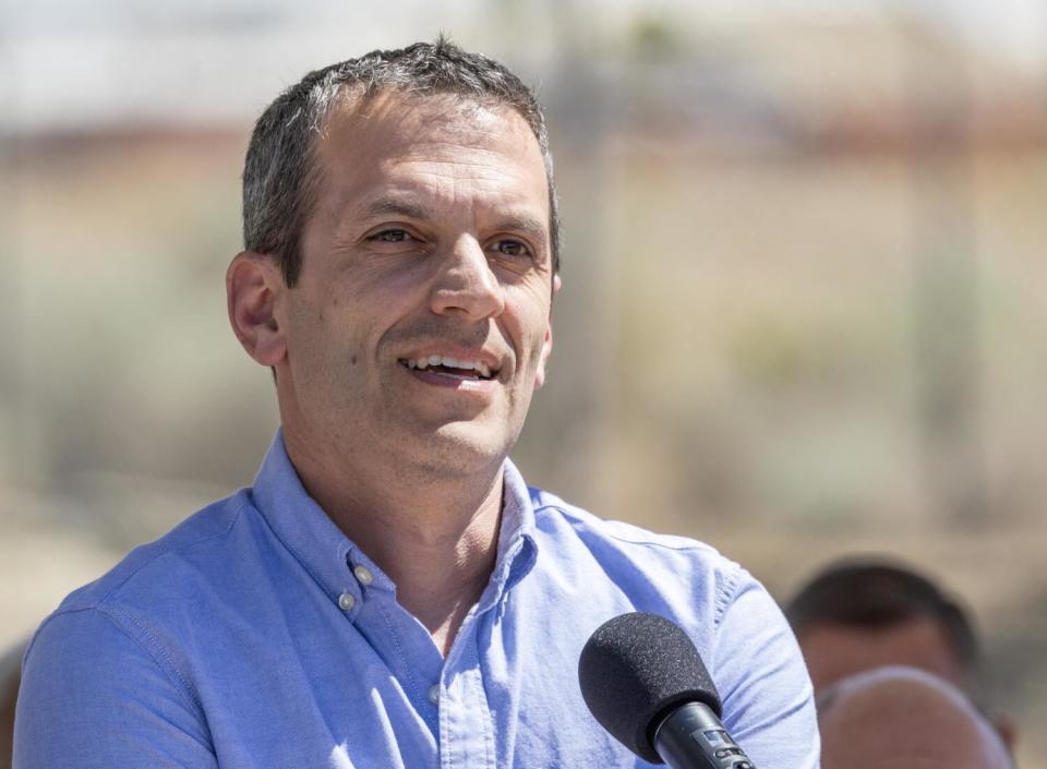 A man stands at a microphone outdoors.