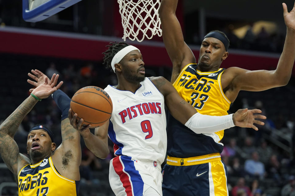 Detroit Pistons forward Jerami Grant (9) passes as Indiana Pacers center Myles Turner (33) defends during the first half of an NBA basketball game, Wednesday, Nov. 17, 2021, in Detroit. (AP Photo/Carlos Osorio)