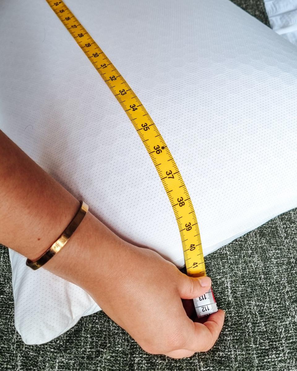 A Purple Harmony Pillow being measured with a measuring tape