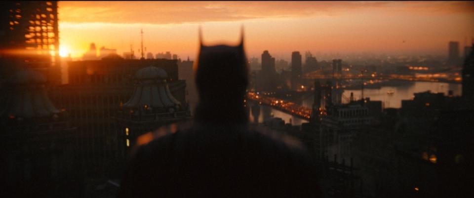 Batman (Robert Pattinson) looks out at Gotham City in The Batman. (Still: Warner Bros Pictures)