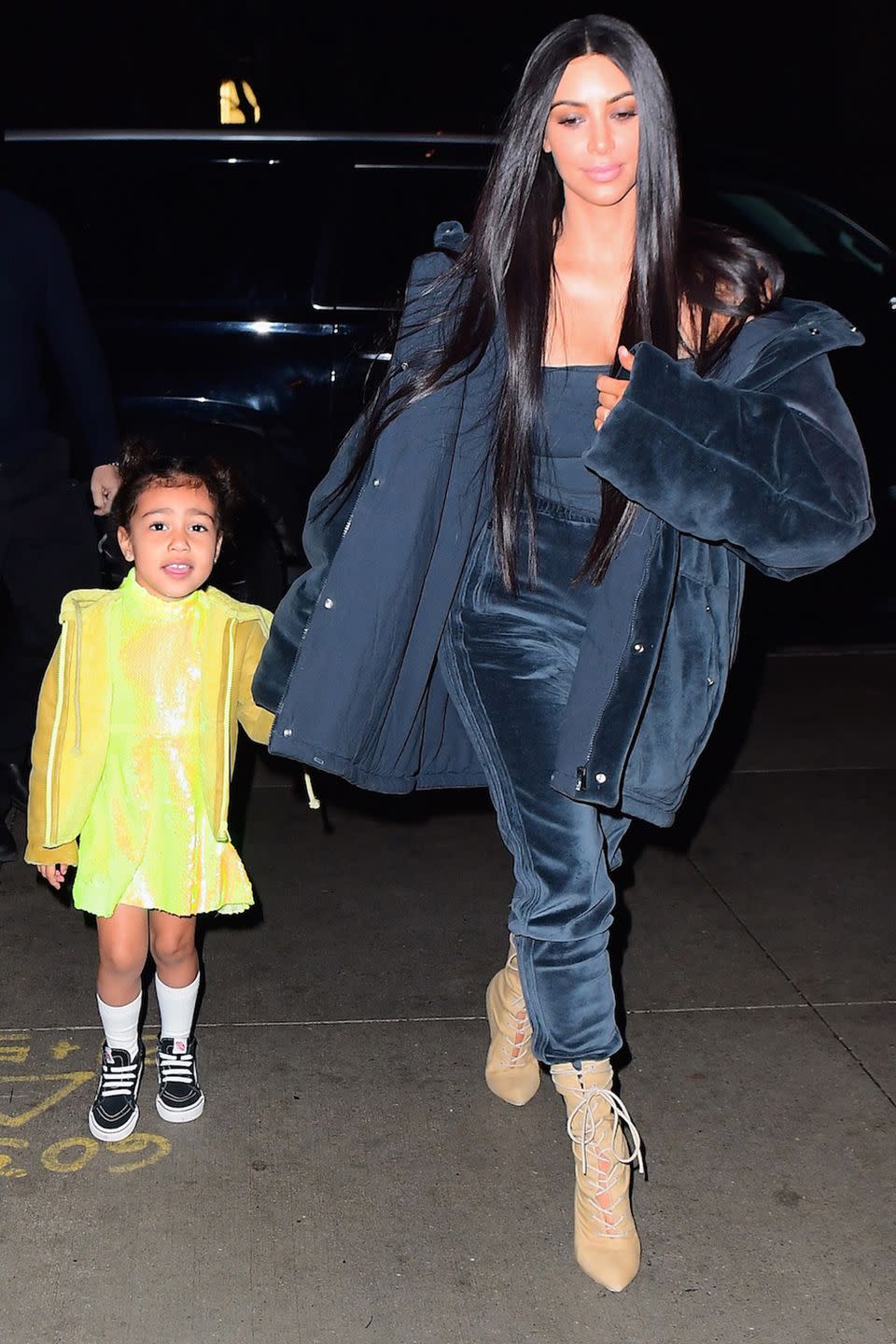 <p>In a dark teal velvet puffer jacket, tube top, velvet track pants, and tan lace-up booties while out with her daughter North West.</p>