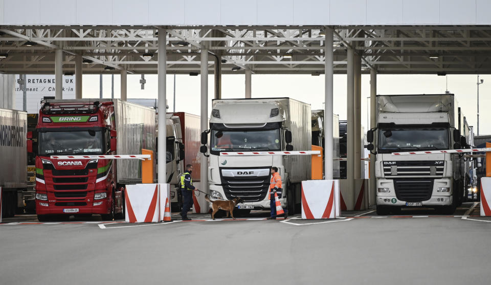 An employee of Eurotunnel and his dog check trucks on their way to Great Britain during a day of test in case of no deal Brexit, at the exit of the Channel tunnel in Calais, northern France, Tuesday, Sept. 17, 2019. British Prime Minister Boris Johnson has said after a meeting with European Commission President Jean-Claude Juncker that "there is a good chance" of a Brexit deal with the European Union. (Denis Charlet, Pool via AP)