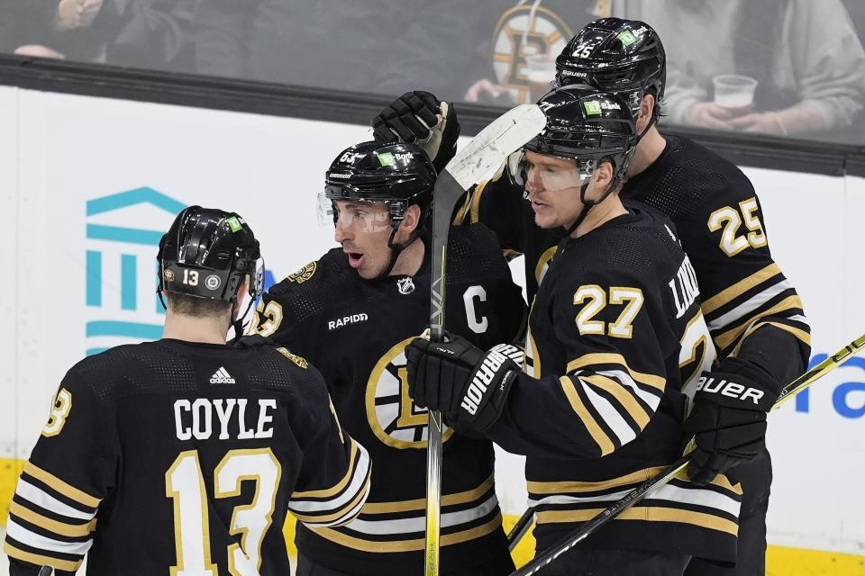 Boston Bruins' Brad Marchand (63) celebrates his goal with teammates Charlie Coyle (13), Hampus Lindholm (27) and Brandon Carlo (25) during the second period of an NHL hockey game against the Pittsburgh Penguins, Saturday, March 9, 2024, in Boston. (AP Photo/Michael Dwyer)