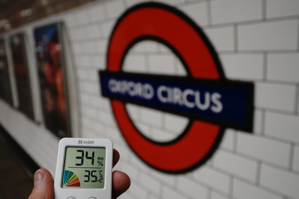 A digital thermometer shows a reading of 34°C (93.2°F) at Oxford Circus station in London.