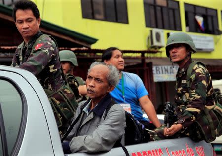 A rescued resident is seen with government forces after he was rescued from his home in Marawi city, Philippines June 21, 2017. REUTERS/Romeo Ranoco