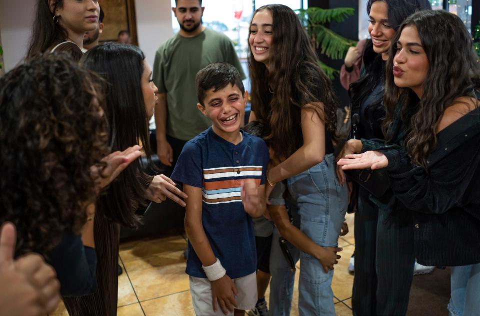 Saleh Humaid, 8, of Gaza, center, is surrounded by women saying goodbye during his going-away party at Masri Sweets in Dearborn on Tuesday Aug. 8, 2023. The party was held for people affiliated with the Palestine Children's Relief Fund Detroit chapter who had interactions with Saleh, taking him out on different activities during his stay in the United States to receive a prosthetic leg and rehabilitation, to say goodbye.