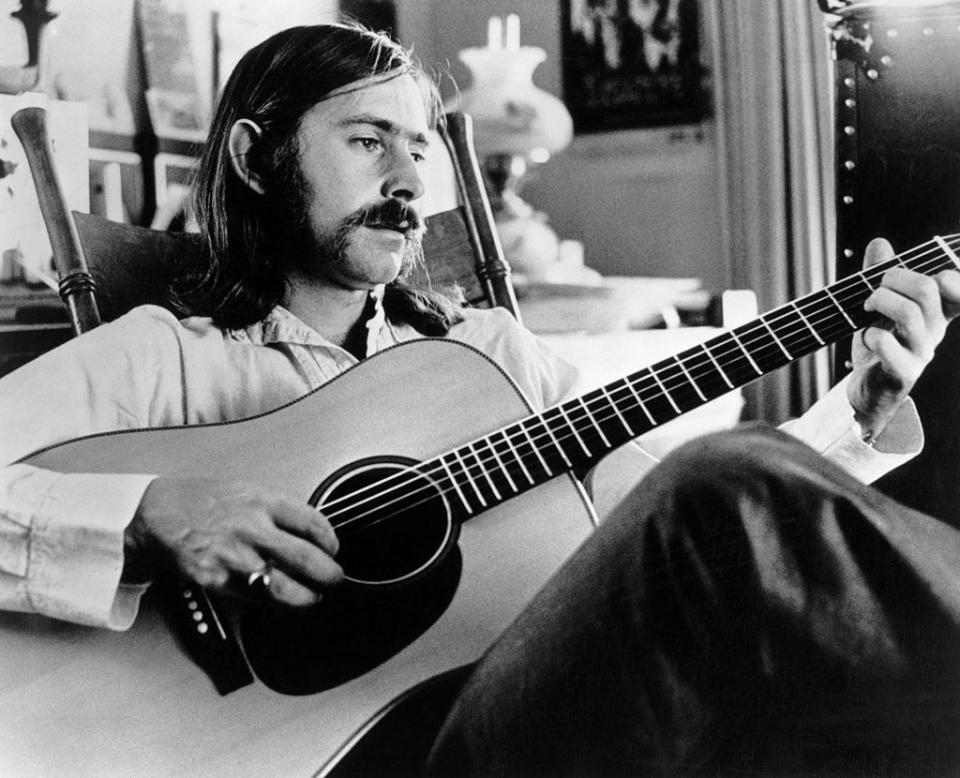 Greenbaum strumming an acoustic guitar