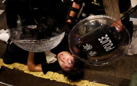 Demonstrator is detained by police officers during a protest in Hong Kong