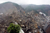 Rescue workers and local residents look for survivors in the ruins of the destroyed old city district, near a mountain at the earthquake-hit Beichuan county, Sichuan province, China, May 15, 2008. REUTERS/Jason Lee/File Photo