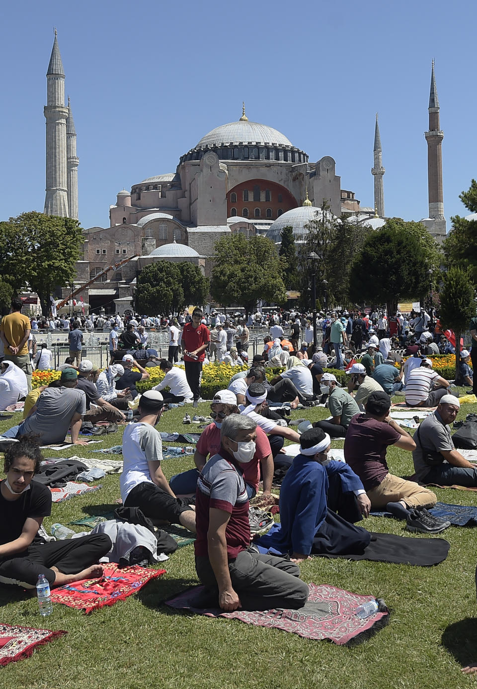 Faithful wait at the historic Sultanahmet district of Istanbul, outside the Byzantine-era Hagia Sophia, Friday, July 24, 2020. Hundreds of Muslim faithful were making their way to Istanbul's landmark monument Friday to take part in the first prayers in 86 years at the structure that was once Christendom's most significant cathedral and the "jewel" of the Byzantine Empire then a mosque and museum before its re-conversion into a Muslim place of worship. The conversion of the edifice, has led to an international outcry. (AP Photo/Yasin Akgul)