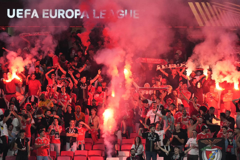 Benfica supporters light flares at the stand during the Europa League quarterfinals, first leg, soccer match between SL Benfica and Olympique de Marseille at the Luz stadium in Lisbon, Thursday, April 11, 2024. (AP Photo/Armando Franca)