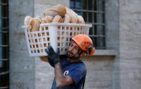 <p>A rescuer carries bread following the earthquake in Amatrice, central Italy, Aug. 24, 2016. (REUTERS/Stefano Rellandini) </p>