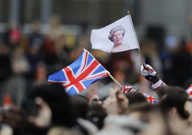 A man waves a British union flag and a flag bearing the image of Britain's Queen Elizabeth II ahead of the annual Commonwealth Day service at Westminster Abbey in London on March 9, 2020. (Photo: AP Photo/Frank Augstein, File)