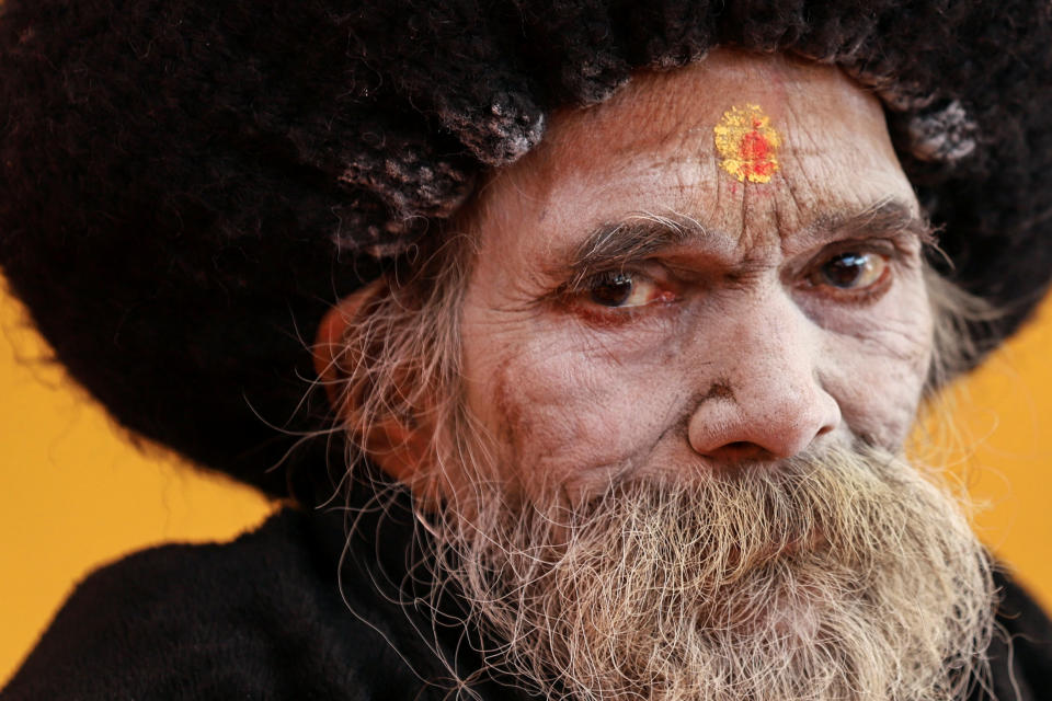 A Sadhu or a Hindu holy man watches a religious ceremony