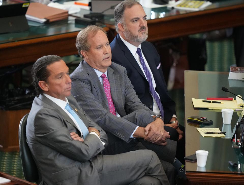 Suspended Texas Attorney General Ken Paxton, middle, listens to closing arguments Friday in his impeachment trial with his attorneys Tony Buzbee, left, and Mitch Little in the Texas Senate chamber.