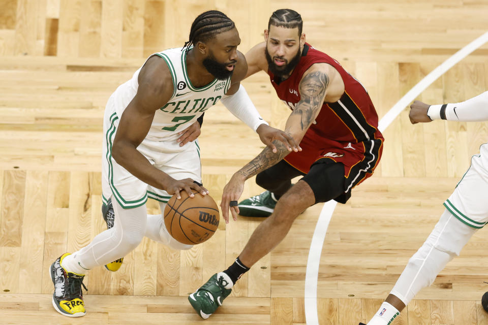 Boston Celtics guard Jaylen Brown, left, drives to the basket against Miami Heat forward Caleb Martin during the second half of Game 2 of the NBA basketball playoffs Eastern Conference finals in Boston, Friday, May 19, 2023. (AP Photo/Michael Dwyer)