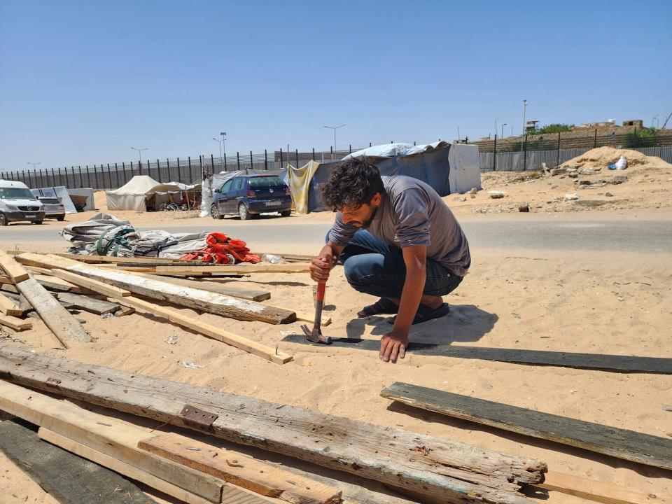 A Palestinian man dismantles a makeshift tent as Palestinians, including women and children, living in makeshift tents at the foot of the wall separating the Gaza Strip and Egypt (Anadolu via Getty Images)