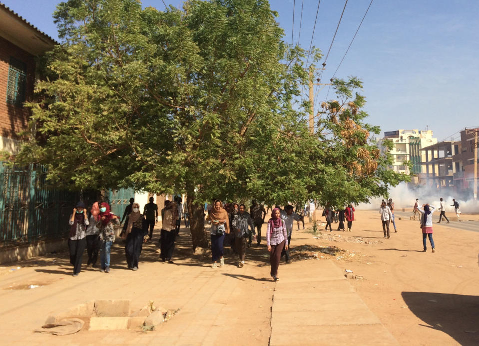 People react to tear gas fired by Sudanese police at anti-government protesters in Khartoum, Sudan, Sunday, Jan. 13, 2019. Hundreds of protesters are marching again in and around Sudan's capitol Khartoum, the fourth week of unrest that began over the rising price of bread and a failing economy but which now calls for the ouster of autocratic President Omar al-Bashir. (AP Photo)