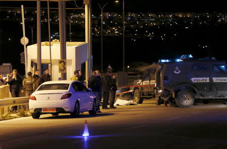 Israeli troops stand next to the covered body of a Palestinian whom they shot dead near the A-Zayyim checkpoint on the outskirts of East Jerusalem in the occupied West Bank April 25, 2015. REUTERS/Ammar Awad