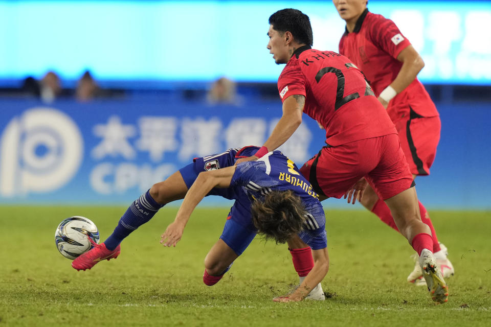 Japan's Yuta Matsumura, left, battles for the ball against South Korea's Park Kyu-Hyun during their men's soccer gold medal match at the 19th Asian Games in Hangzhou, China, Saturday, Oct. 7, 2023. (AP Photo/Aijaz Rahi)